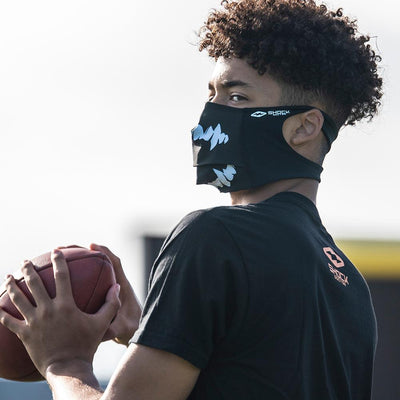 Black White Fang Play Safe Face Mask – Male Football Player Wearing Protective Safety Face Mask while Getting Ready to Throw Ball to a Receiver - Left Angle